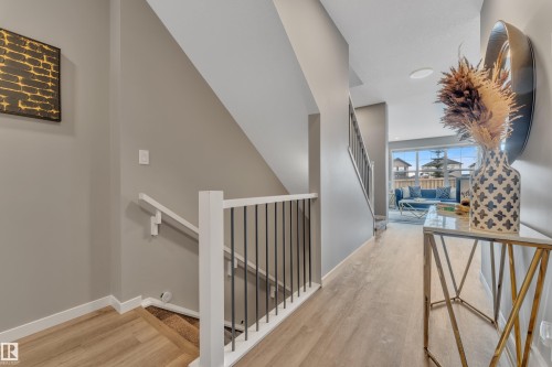 The property features light-toned flooring, a staircase with white railings and dark balusters, and neutral-colored walls - 21853 98A Avenue, Edmonton, AB - Indoor Photo Showing Other Room