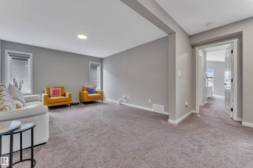 The living area features neutral gray walls, light gray carpet, and recessed lighting - 21853 98A Avenue, Edmonton, AB - Indoor