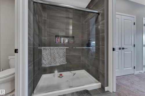 Bathroom featuring a tiled shower with a glass enclosure and a built-in shower niche - 21853 98A Avenue, Edmonton, AB - Indoor Photo Showing Bathroom