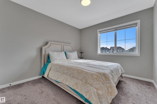 This bedroom features a window with white trim, gray walls, and gray carpeting - 21853 98A Avenue, Edmonton, AB - Indoor Photo Showing Bedroom