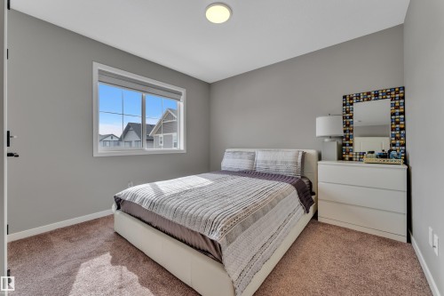 This room features a window with a view of residential rooftops and blue sky, light grey walls, and a ceiling light fixture - 21853 98A Avenue, Edmonton, AB - Indoor Photo Showing Bedroom