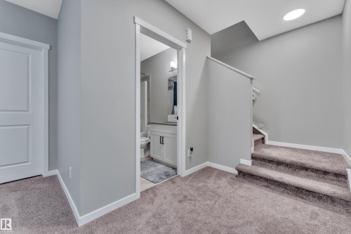 The property features a staircase with carpeted treads and a light-colored handrail, leading to an upper level - 21853 98A Avenue, Edmonton, AB - Indoor Photo Showing Other Room