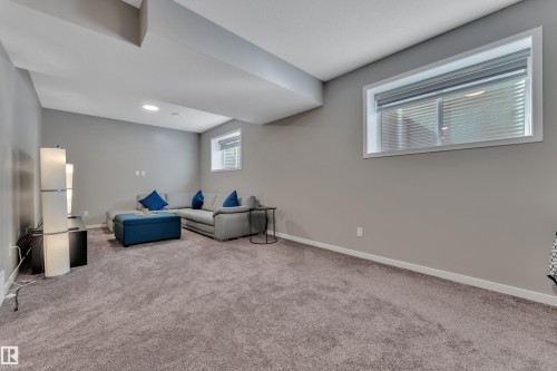 The property features a spacious room with light gray walls, gray carpeting, and recessed lighting - 21853 98A Avenue, Edmonton, AB - Indoor