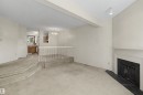 Living area featuring a fireplace with a white mantel and dark hearth, track lighting, and carpeted flooring - 5953 40 Avenue, Edmonton, AB  - Indoor With Fireplace 