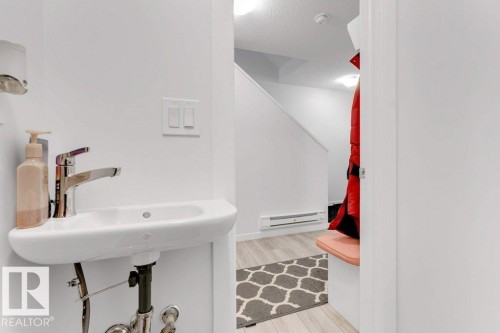 Compact wall-mounted sink with a chrome faucet and light wood-finish flooring - 53 1110 Daniels Link Link, Edmonton, AB - Indoor Photo Showing Bathroom