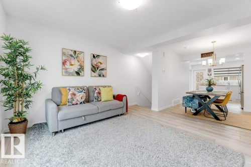 Open-concept living space featuring light wood-finish flooring, white walls, and recessed lighting - 53 1110 Daniels Link Link, Edmonton, AB - Indoor Photo Showing Living Room