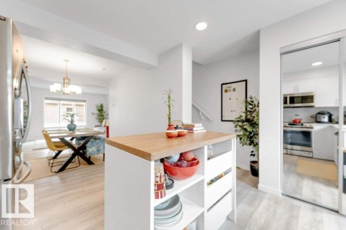 Kitchen island with a wood-finish countertop and open shelving - 53 1110 Daniels Link Link, Edmonton, AB - Indoor Photo Showing Other Room