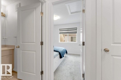 Interior doorway revealing a room with carpet flooring, a window with horizontal blinds, and a built-in light fixture - 53 1110 Daniels Link Link, Edmonton, AB - Indoor Photo Showing Other Room