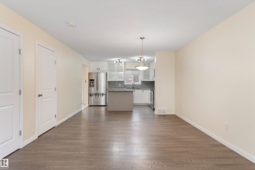Open-concept living area featuring wood-finish flooring, light-toned walls, and white trim - 336 Watt Boulevard, Edmonton, AB - Indoor Photo Showing Other Room