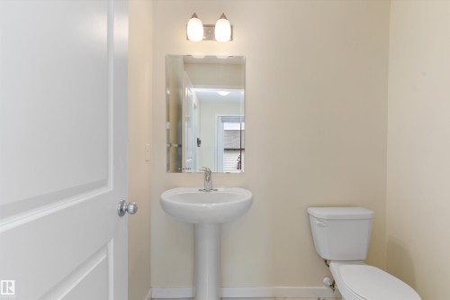 Pedestal sink with chrome faucet, mirror, and overhead vanity lighting - 336 Watt Boulevard, Edmonton, AB - Indoor Photo Showing Bathroom