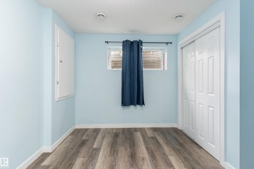 Room featuring wood-finish flooring, light blue walls, and a white bi-fold closet door - 336 Watt Boulevard, Edmonton, AB - Indoor Photo Showing Other Room