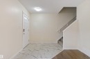 Entryway featuring a white paneled door with glass inserts, recessed lighting, and a combination of marble-look tile and wood-finish flooring - 336 Watt Boulevard, Edmonton, AB  - Indoor Photo Showing Other Room 
