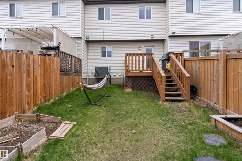 Rear exterior featuring a wooden deck with railing, stairs, and lattice skirting - 336 Watt Boulevard, Edmonton, AB - Outdoor With Exterior