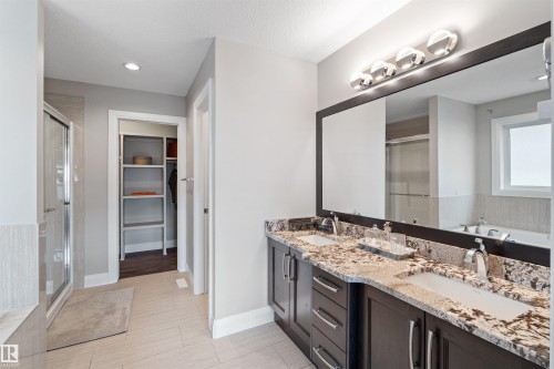 Dual vanity with granite countertops, undermount sinks, and dark wood cabinetry - 3807 Claxton Close, Edmonton, AB - Indoor Photo Showing Bathroom