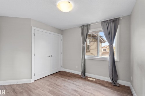 Room featuring wood-finish flooring, white baseboards, and light gray walls - 3807 Claxton Close, Edmonton, AB - Indoor Photo Showing Other Room