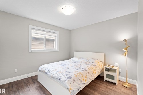Room featuring wood-finish flooring, a white window frame, and a flush-mount ceiling light - 3807 Claxton Close, Edmonton, AB - Indoor Photo Showing Bedroom