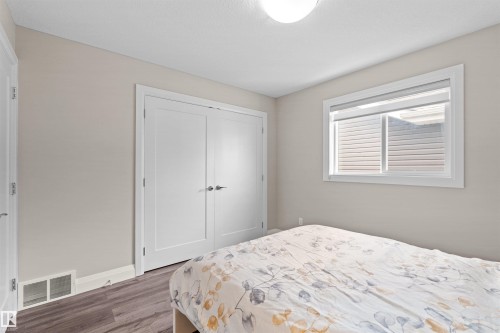 Bedroom featuring light neutral paint, a single window with roller blinds, and wood-finish flooring - 3807 Claxton Close, Edmonton, AB - Indoor Photo Showing Bedroom
