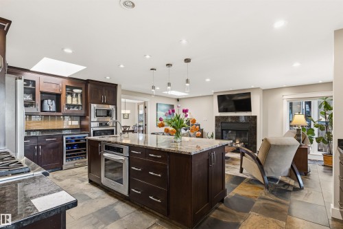 Kitchen island with granite countertop and integrated oven - 9010 120 Street, Edmonton, AB - Indoor Photo Showing Kitchen With Upgraded Kitchen