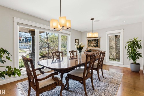Dining space featuring wood-finish flooring, white trim, and multiple large windows - 9010 120 Street, Edmonton, AB - Indoor Photo Showing Dining Room