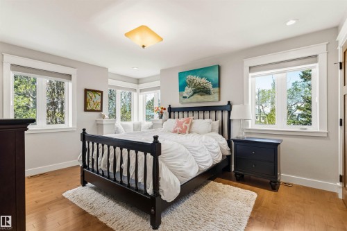 Light wood-finish flooring complements the neutral wall tones - 9010 120 Street, Edmonton, AB - Indoor Photo Showing Bedroom