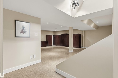 Open concept lower level featuring recessed lighting, light-toned walls, and a staircase with a white railing - 9010 120 Street, Edmonton, AB - Indoor Photo Showing Other Room