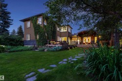 Expansive lawn with stone pathway leading to a multi-level dwelling - 