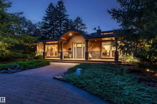Architectural facade featuring a distinctive arched entry, stone veneer accents, and wide window openings - 9010 120 Street, Edmonton, AB - Outdoor With Deck Patio Veranda