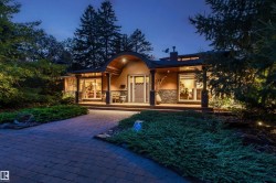 Architectural facade featuring a distinctive arched entry, stone veneer accents, and wide window openings - 