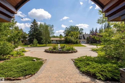Paved circular driveway with a central stone-edged planter - 9010 120 Street, Edmonton, AB - Outdoor