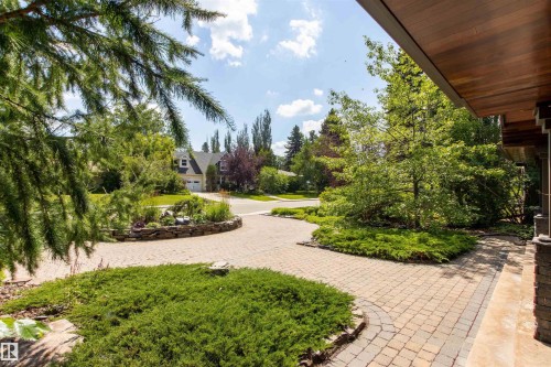 Expansive paver driveway with integrated stone landscaping beds - 9010 120 Street, Edmonton, AB - Outdoor