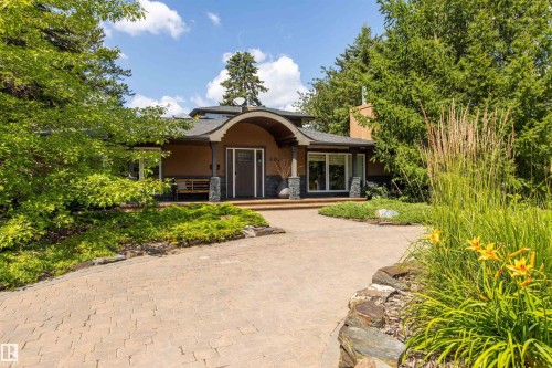 Arched entryway with stone-clad columns and a dark wood door - 9010 120 Street, Edmonton, AB - Outdoor With Deck Patio Veranda
