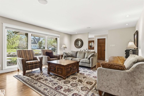 Living space featuring light wood-finish flooring and a decorative area rug - 9010 120 Street, Edmonton, AB - Indoor Photo Showing Living Room