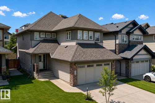 Two-story residence featuring composite shingle roofing, horizontal siding, and stone accents - 469 Ainslie Crescent Sw, Edmonton, AB - Outdoor With Facade