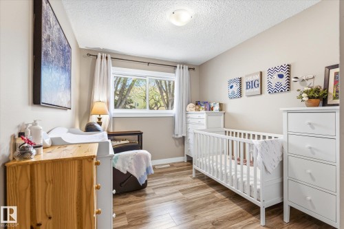 Well-lit room featuring wood-finish flooring and a neutral wall color - 111 Grosvenor Boulevard, St. Albert, AB - Indoor Photo Showing Bedroom