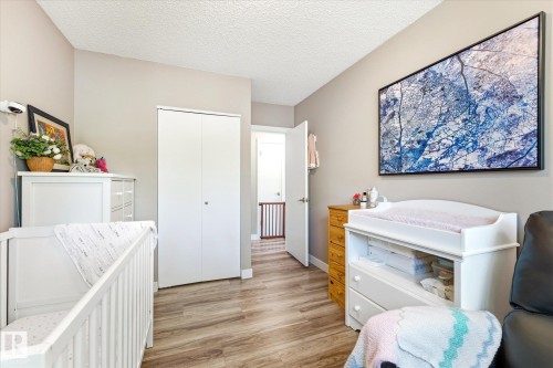 Wood-finish flooring throughout, smooth neutral-toned walls, and a recessed closet with bi-fold doors - 111 Grosvenor Boulevard, St. Albert, AB - Indoor