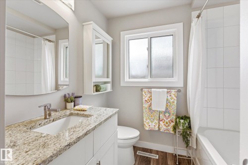 White vanity with a granite-style countertop and integrated sink - 111 Grosvenor Boulevard, St. Albert, AB - Indoor Photo Showing Bathroom