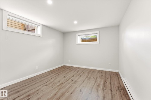 Room featuring light gray walls, wood-finish flooring, recessed lighting, and two horizontally oriented windows with white trim - 111 Grosvenor Boulevard, St. Albert, AB - Indoor Photo Showing Other Room