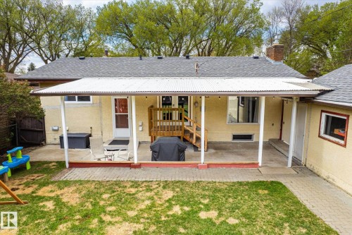 Expansive backyard featuring a covered patio, brick paver accents, a manicured lawn, and mature trees - 111 Grosvenor Boulevard, St. Albert, AB - Outdoor With Deck Patio Veranda
