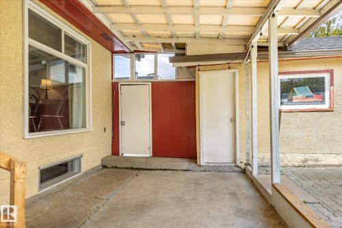 Covered outdoor space featuring stucco exterior, multiple entry points, and varied window placements - 111 Grosvenor Boulevard, St. Albert, AB - Indoor