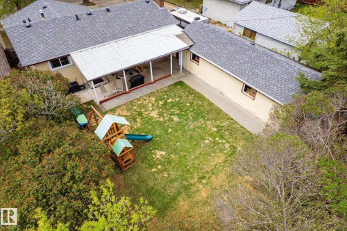 Expansive backyard featuring a covered patio, manicured lawn, and mature perimeter foliage - 111 Grosvenor Boulevard, St. Albert, AB - Outdoor With Deck Patio Veranda