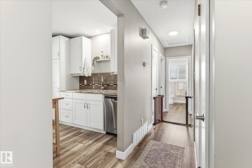 Modern kitchen featuring white cabinetry, stainless steel appliances, granite countertops, and a subway tile backsplash - 111 Grosvenor Boulevard, St. Albert, AB - Indoor