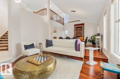 Spacious living area featuring polished wood-finish flooring, a vaulted ceiling, and ample natural light from multiple windows - 956 Ogilvie Boulevard, Edmonton, AB - Indoor Photo Showing Living Room