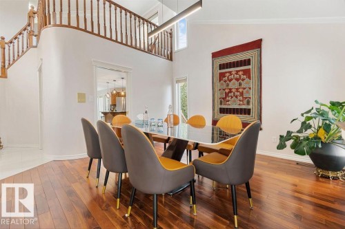 Dining area featuring wood-finish flooring, high ceilings, and an open concept balcony with wood railing - 956 Ogilvie Boulevard, Edmonton, AB - Indoor Photo Showing Dining Room