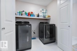 Dedicated laundry area featuring white tile flooring and a wall-mounted shelving unit - 
