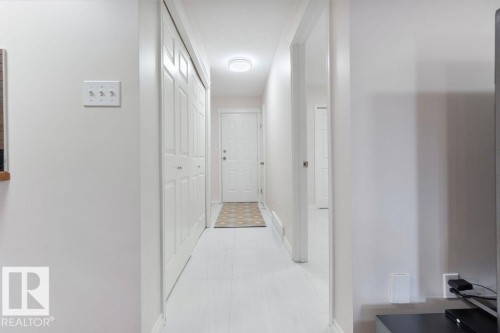 Entryway featuring white bi-fold closet doors, a white paneled door, and light-colored flooring - 956 Ogilvie Boulevard, Edmonton, AB - Indoor Photo Showing Other Room