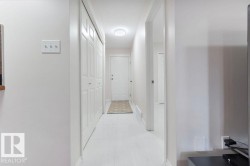 Entryway featuring white bi-fold closet doors, a white paneled door, and light-colored flooring - 