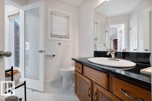 Bathroom vanity featuring a dark countertop, white oval sink, and brushed nickel faucet - 956 Ogilvie Boulevard, Edmonton, AB - Indoor Photo Showing Bathroom