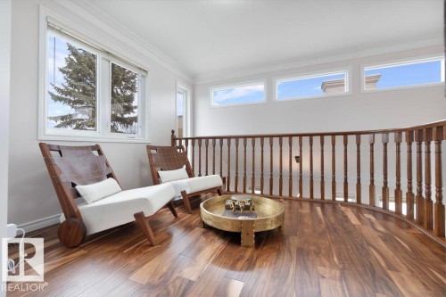 Upper-level landing featuring polished wood-finish flooring and a curved wood balustrade - 956 Ogilvie Boulevard, Edmonton, AB - Indoor Photo Showing Other Room