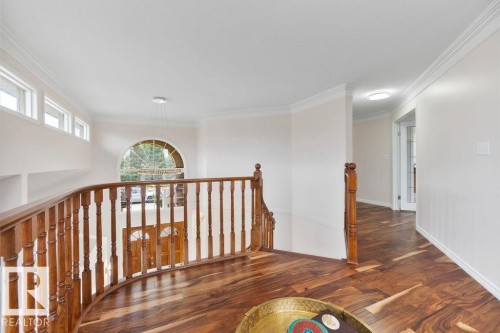 Upper landing featuring wood-finish flooring, a wood baluster railing, and white crown molding - 956 Ogilvie Boulevard, Edmonton, AB - Indoor Photo Showing Other Room