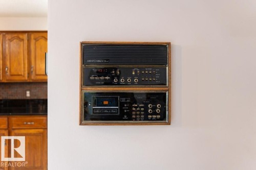 Built-in intercom system with integrated audio player, framed in wood, and mounted on a white wall - 956 Ogilvie Boulevard, Edmonton, AB - Indoor Photo Showing Other Room